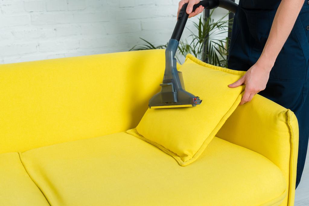 cropped view of man removing dust on pillow with vacuum cleaner  - Photo, Image