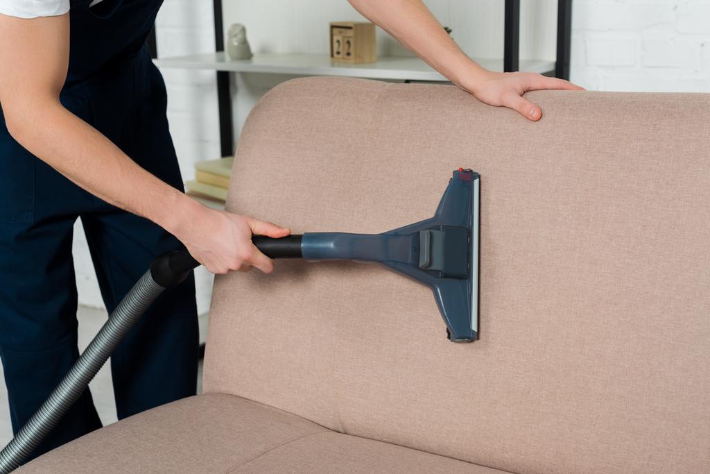 rajattu näkymä siivooja yhtenäinen kuivapesu moderni sohva pölynimurilla
  - Valokuva, kuva