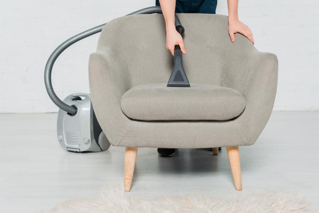 vista recortada de un joven sillón de limpieza en seco con aspiradora moderna
  - Foto, imagen
