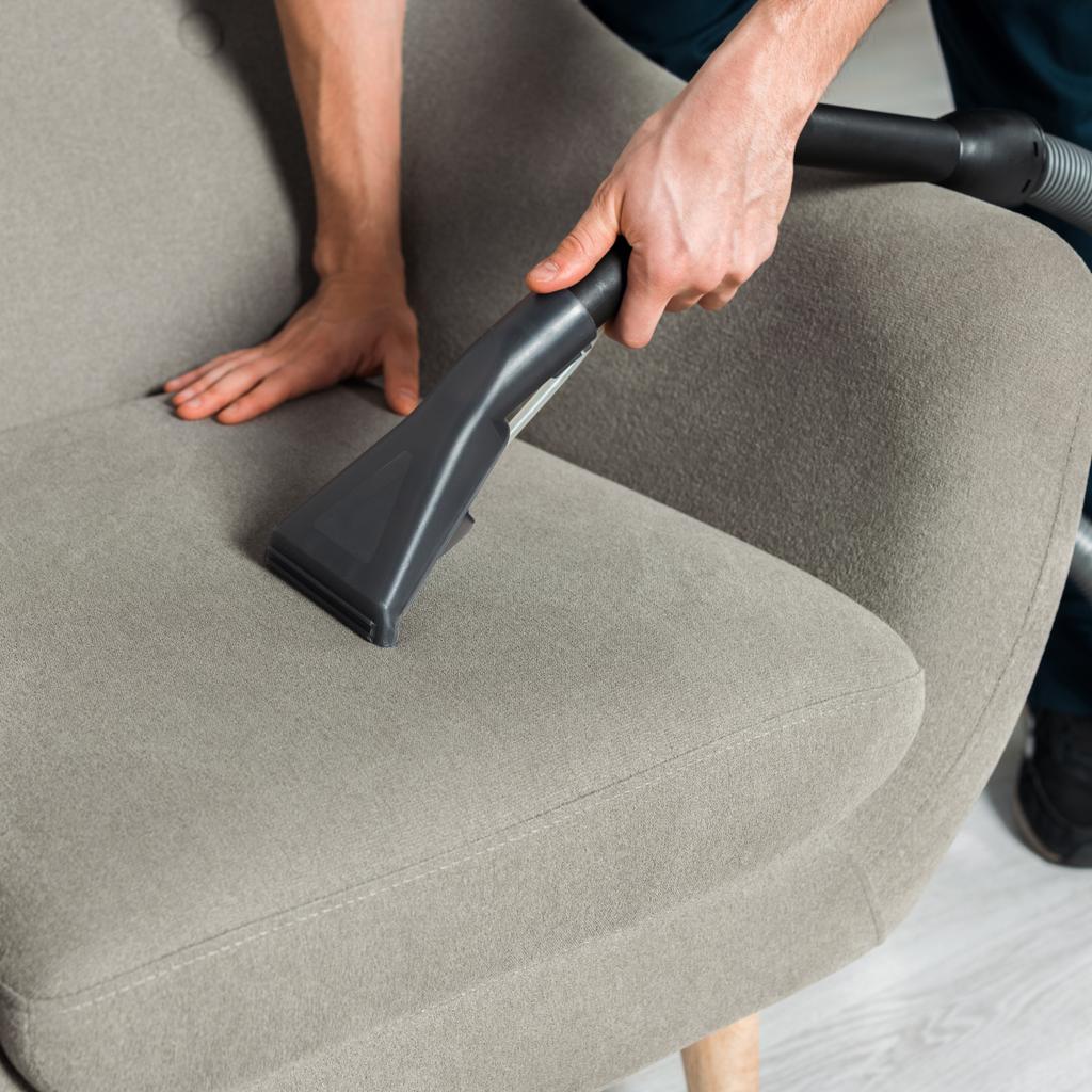 обрезанный вид на более чистое кресло с пылесосом в гостиной
  - Фото, изображение