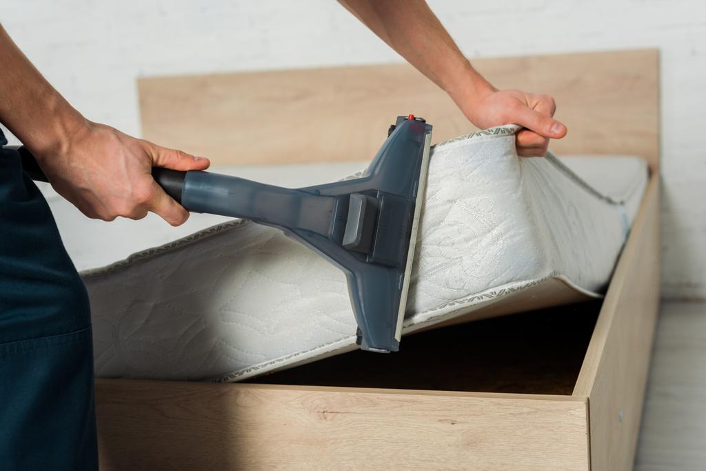 cropped view of man removing dust on mattress with vacuum cleaner  - Photo, Image