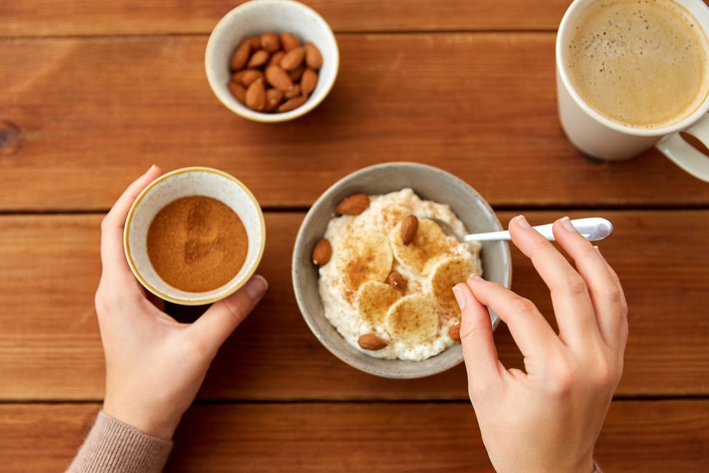 ręce z płatkami owsianymi śniadanie i filiżankę kawy - Zdjęcie, obraz