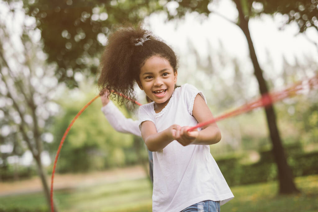 Meisjes spelen touwtrekken in het park - Foto, afbeelding