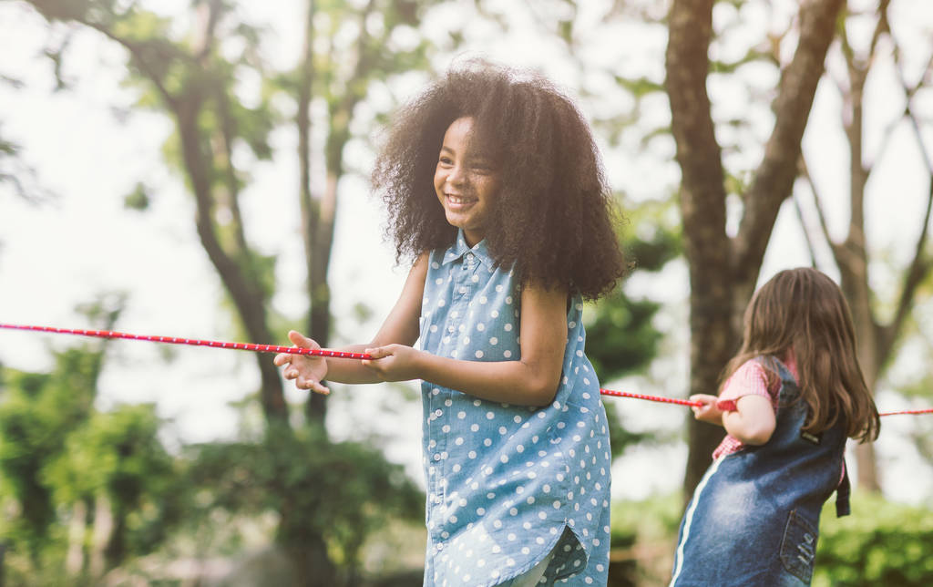 Ευτυχισμένα παιδιά παίζουν διελκυστίνδα στο πάρκο - Φωτογραφία, εικόνα