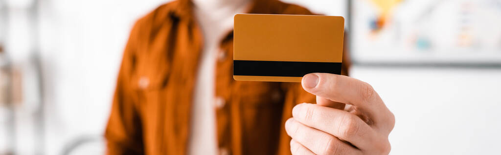 Concentration sélective du concepteur numérique tenant la carte de crédit, vue panoramique
  - Photo, image