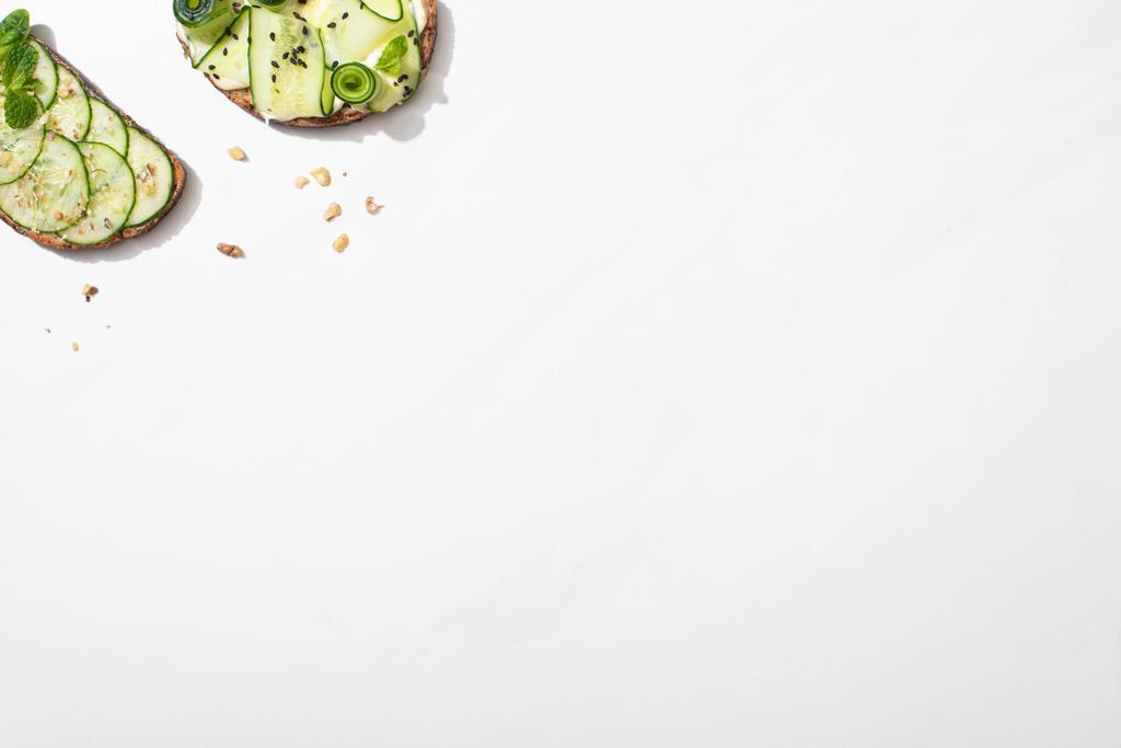Beyaz arka planda taze salatalıklı tostların üst görüntüsü - Fotoğraf, Görsel