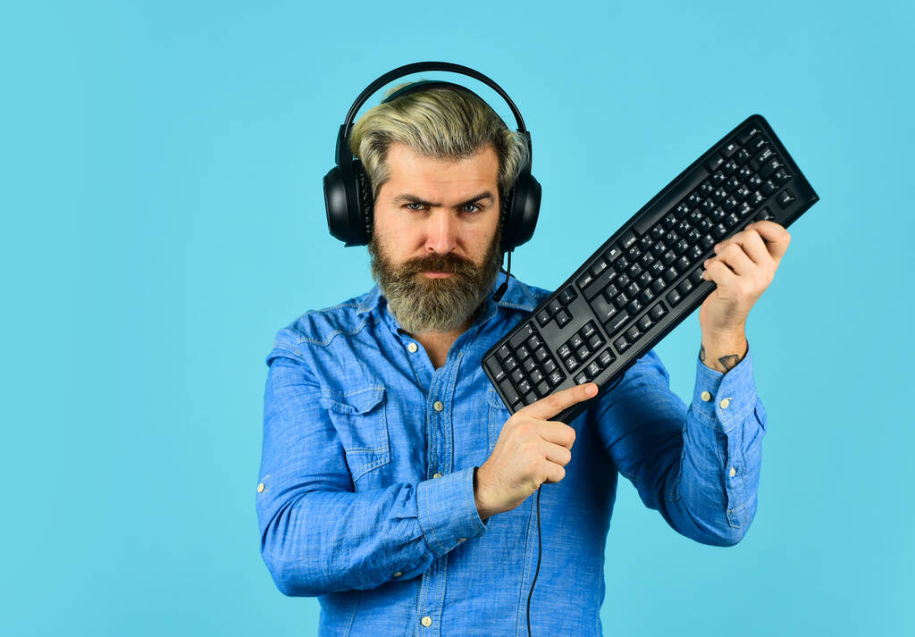 Gaming PC build guide. Graphics settings pushed to limit. Gaming addiction. Online gaming. Modern leisure. Play computer games. Man bearded hipster gamer headphones and keyboard. Run any modern game - Photo, Image