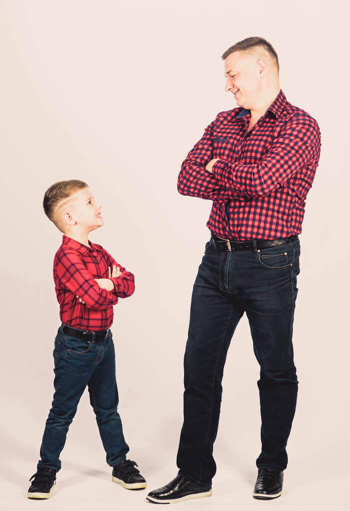 父の小さな息子の赤いシャツの家族の服に見えます。永遠に親友だ少年の父としての幸福。パパと可愛い子親の概念。父の日だ高貴な人間の父の例。いい奴らだ - 写真・画像