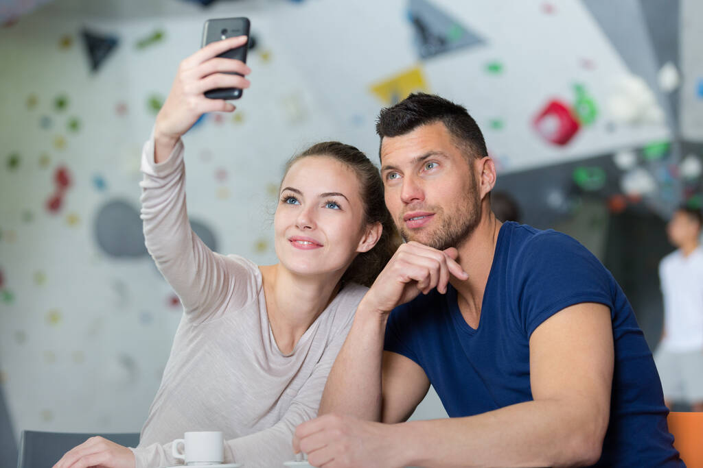 couple taking selfie at indoor climbing wall center - Photo, Image