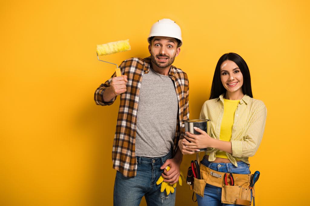 emotional manual workers with paint roller and paint can on yellow   - Photo, Image