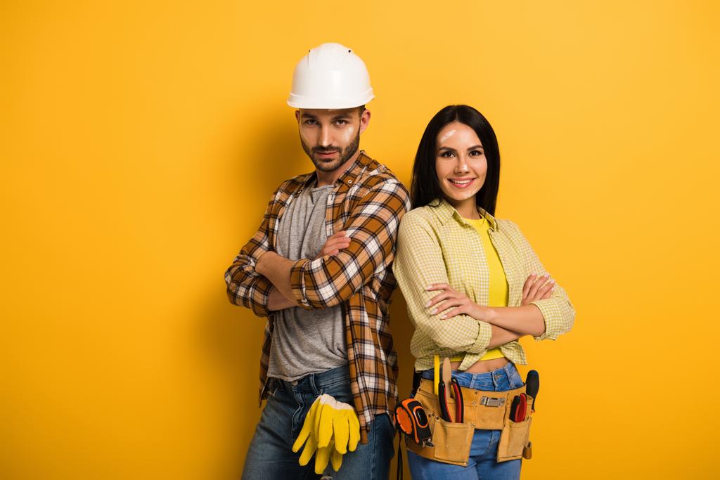 trabalhadores manuais sorridentes confiantes com braços cruzados em amarelo
   - Foto, Imagem