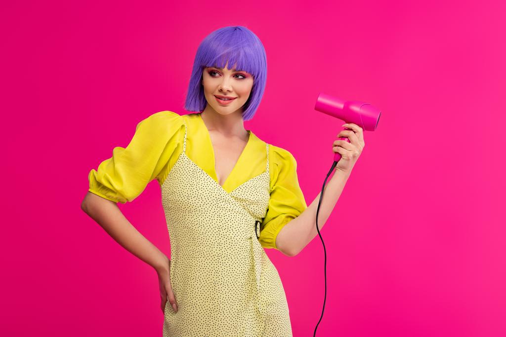 iloinen tyylikäs pop art tyttö violetti peruukki käyttäen hiustenkuivaaja, eristetty vaaleanpunainen
 - Valokuva, kuva