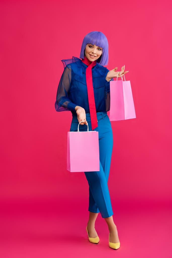 modna dziewczyna w fioletowy peruka gospodarstwa torby na zakupy, na różowy - Zdjęcie, obraz