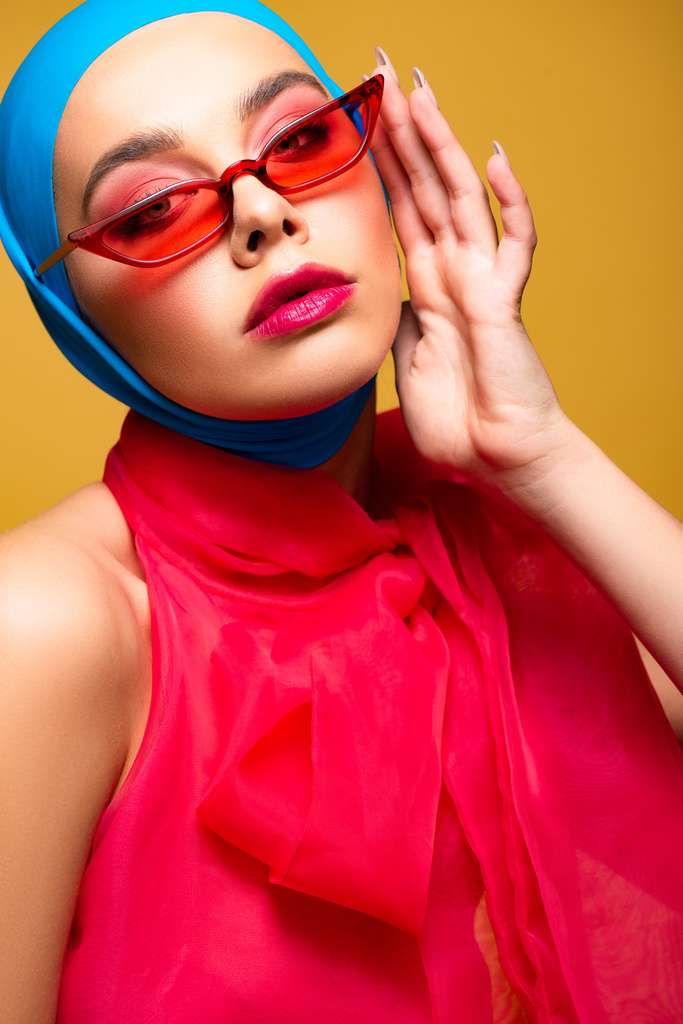 svůdná módní dívka v módní šále a červených slunečních brýlích, izolovaná na žluté - Fotografie, Obrázek