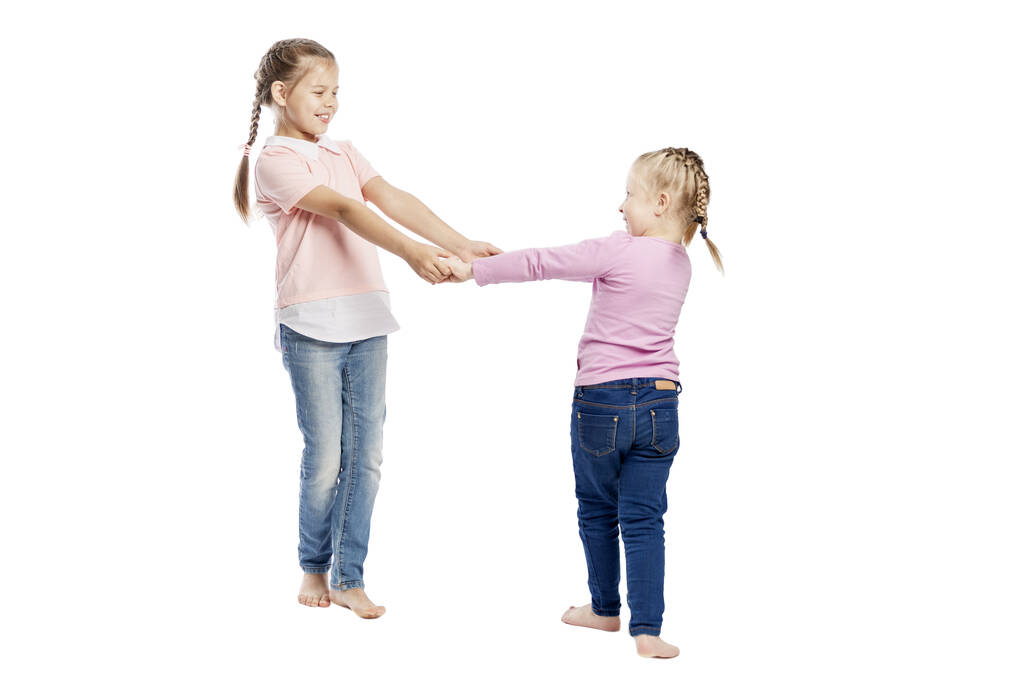 Little girls girlfriends hold hands and laugh. Love and tenderness. Isolated on a white background. - Photo, Image