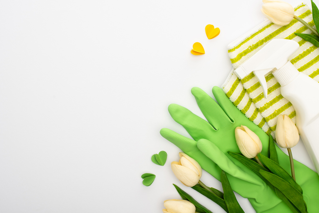 vista superior de tulipas de primavera e suprimentos de limpeza verde e corações no fundo branco
 - Foto, Imagem