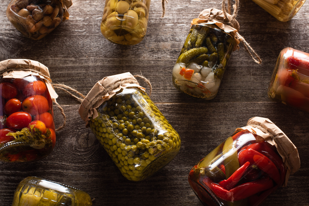 top view of homemade delicious pickles in jars on wooden table - Photo, Image