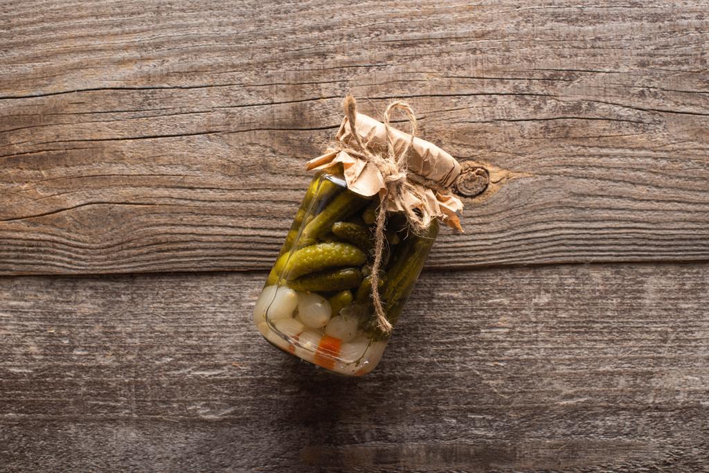 вид зверху домашні смачні консервовані огірки в банці на дерев'яному столі
 - Фото, зображення
