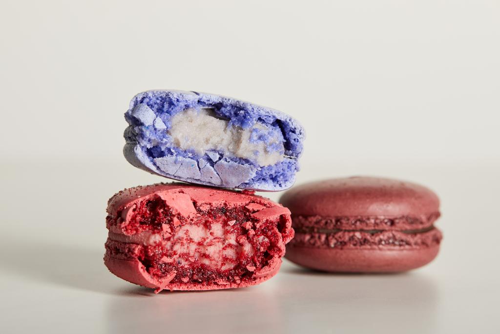 selective focus of assorted delicious bitten colorful french macaroons on white background - Photo, Image