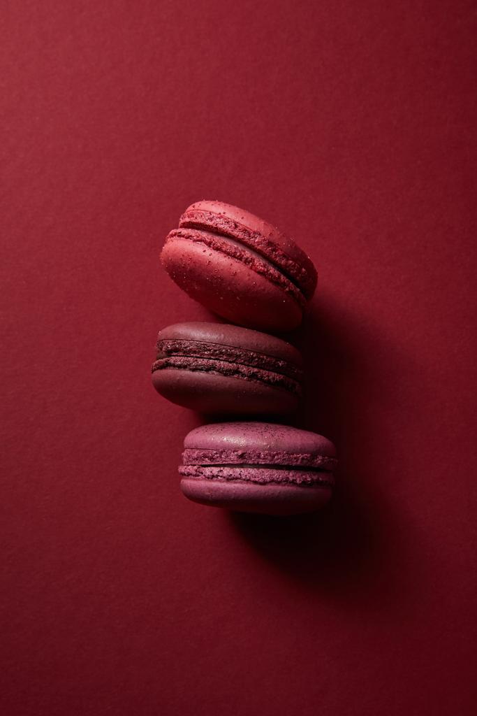 top view of delicious colorful french macaroons on red background - Photo, Image