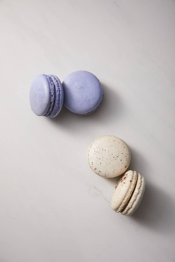 vista dall'alto di deliziosi macaron viola assortiti e bianchi francesi su sfondo grigio
 - Foto, immagini