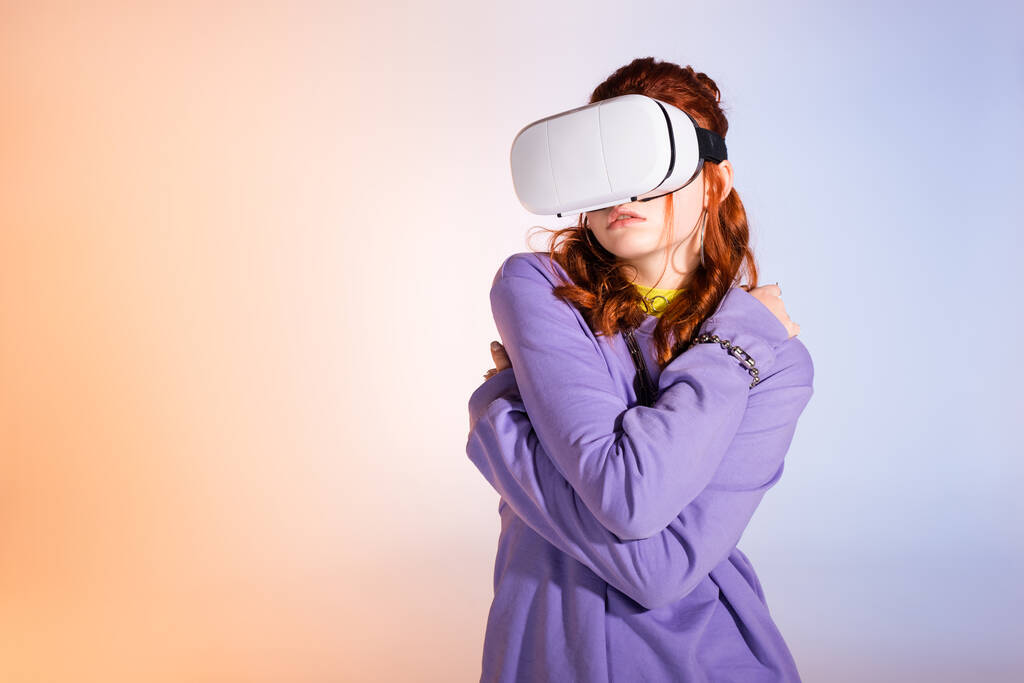 грустная девушка-подросток с помощью гарнитуры виртуальной реальности, на фиолетовый и бежевый
  - Фото, изображение