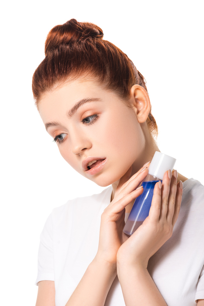 atractiva chica adolescente con la piel limpia celebración botella con removedor de maquillaje azul, aislado en blanco
 - Foto, imagen