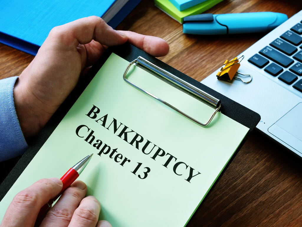 Человек читает главу 13 закона о банкротстве в офисе
. - Фото, изображение