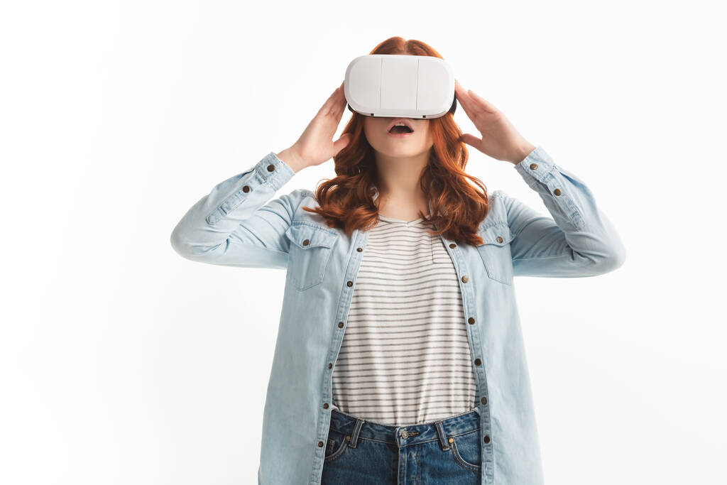 shocked redhead teenager using virtual reality headset, isolated on white - Photo, Image