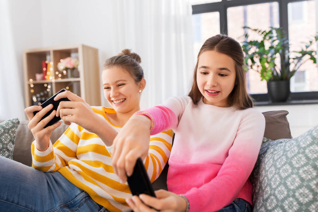 девушки и играть в игры на смартфонах дома
 - Фото, изображение