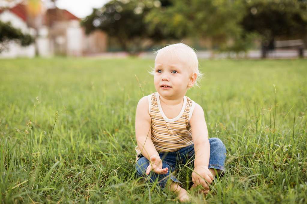 Bambino seduto sull'erba verde
 - Foto, immagini