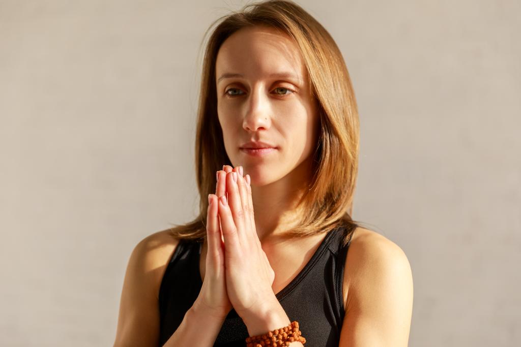 όμορφη γυναίκα με τα χέρια προσεύχεται στο στούντιο γιόγκα  - Φωτογραφία, εικόνα
