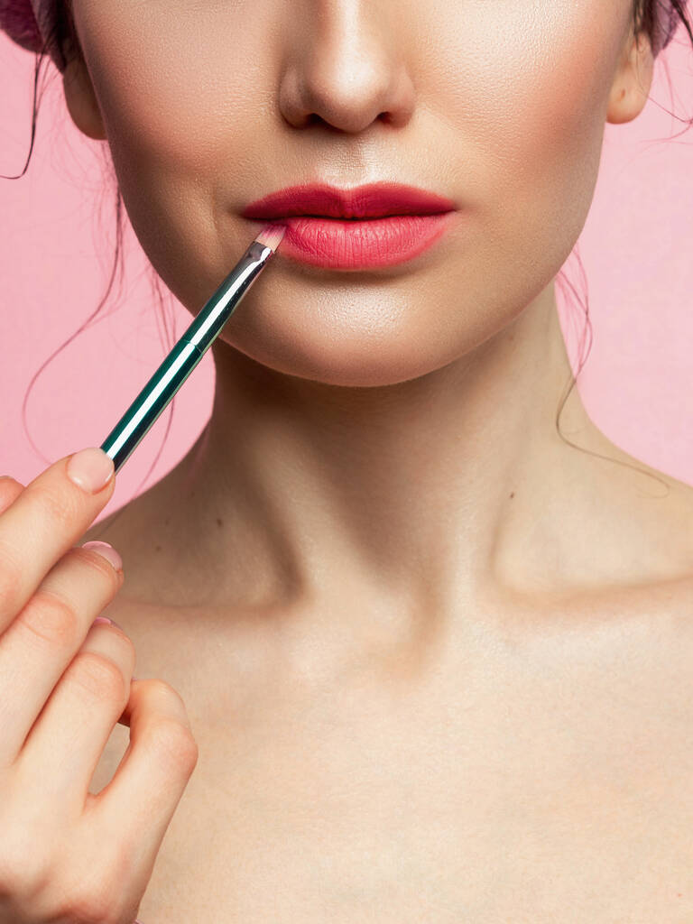 女性には、ピンクの唇が描かれています。美唇メイク。完璧な肌、完全な唇。レトロなを確認します。プロのメイクアップ アーティストがセクシーな唇のメイクを適用します。ファッションメイク - 写真・画像