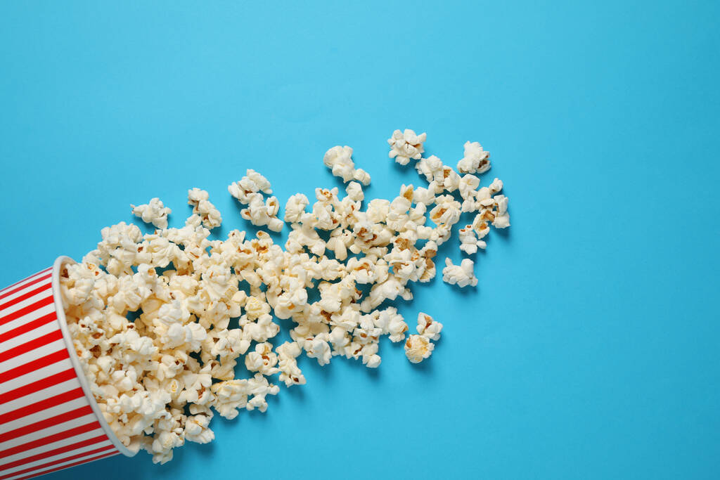 Finom popcorn világoskék háttérrel, felülnézet - Fotó, kép