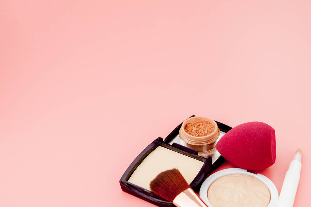 Conjunto de cosméticos coloridos sobre fondo de mesa de madera rosa, base para maquillaje en forma de cojín. Copiar espacio
. - Foto, Imagen