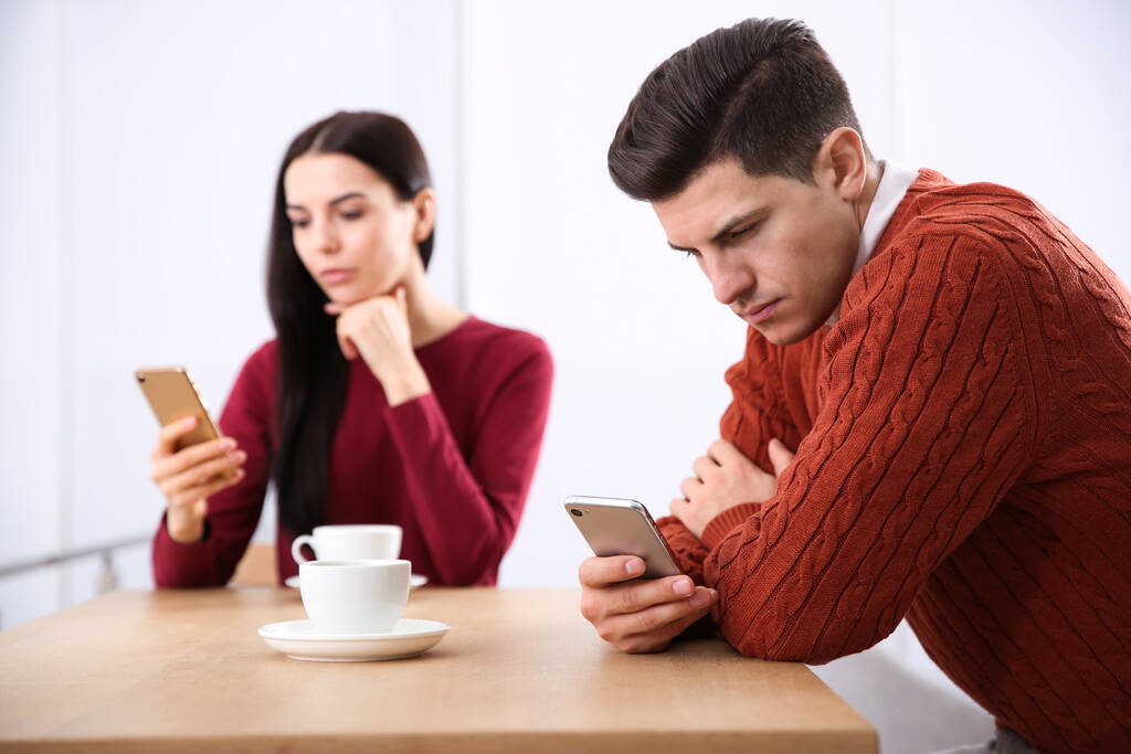 Paar, das süchtig nach Smartphones ist, ignoriert einander im Café. Beziehungsprobleme - Foto, Bild