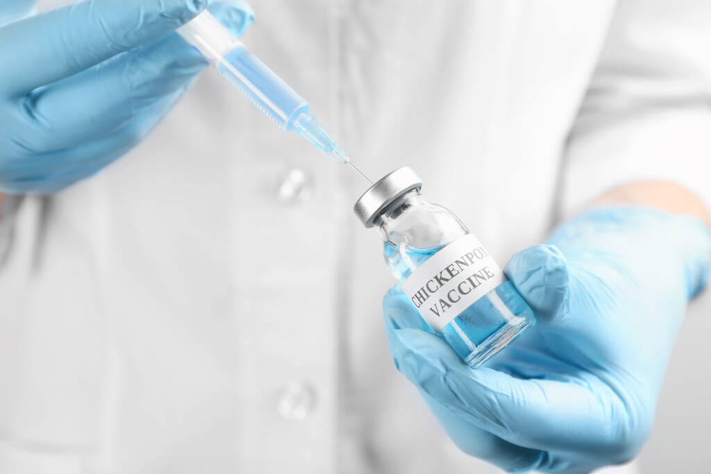 医師は、水痘ワクチンで注射器を埋め、閉じます。バリチェラウイルスの予防 - 写真・画像