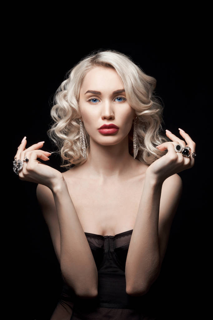 Krásná módní žena s šperky na rukou, vlnité vlasy. Portrét blondýny s prsteny na prstech, krásný make-up na tváři, perfektní účes - Fotografie, Obrázek