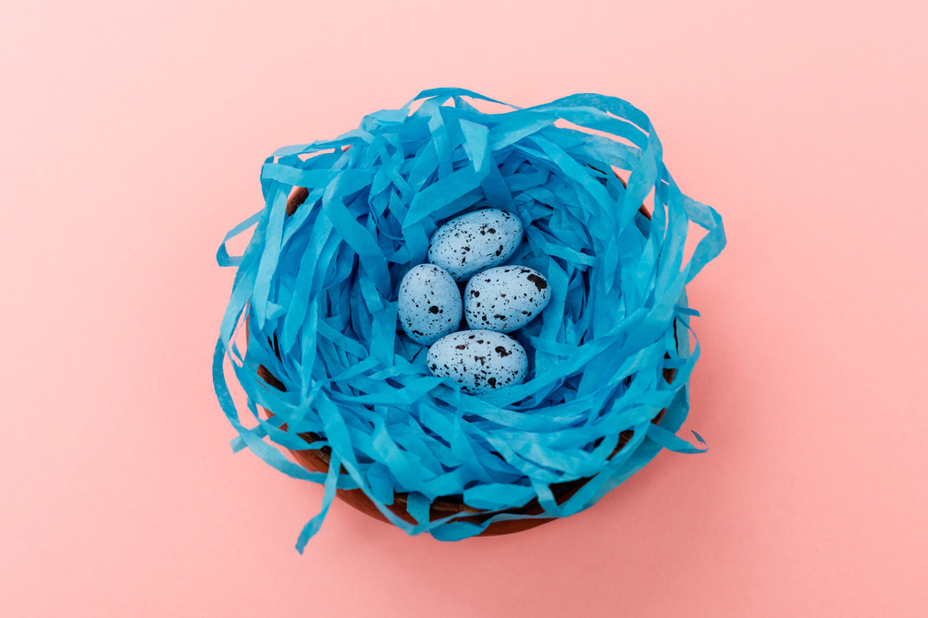 Vista de alto ángulo de huevos de codorniz en nido azul sobre fondo rosa, concepto de Pascua
 - Foto, imagen