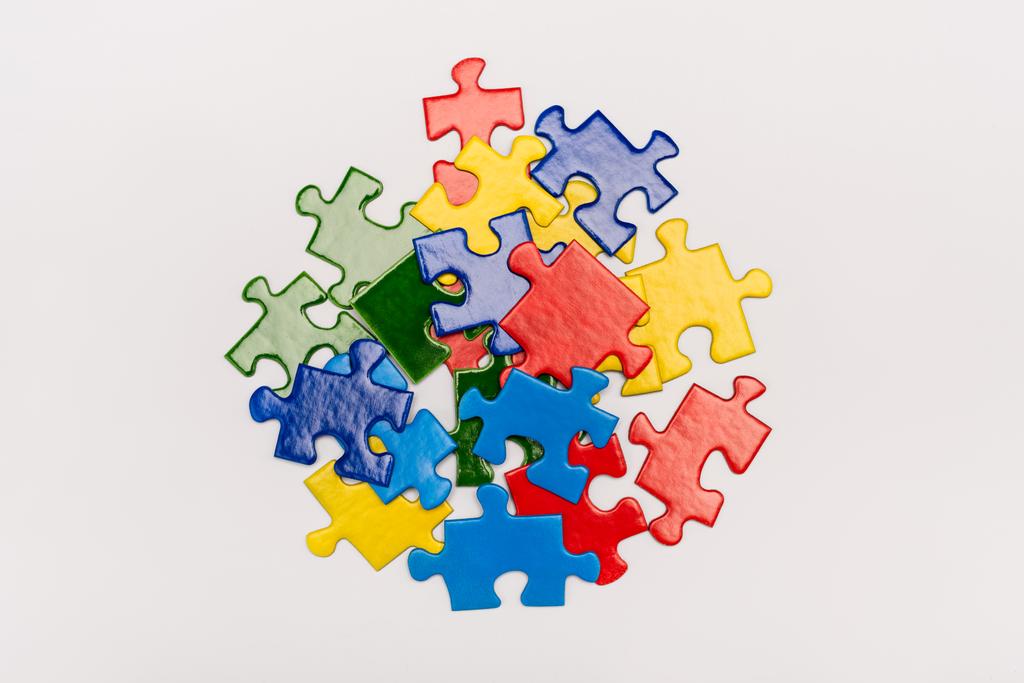 Vista superior de brillantes piezas multicolores de rompecabezas aislado en blanco, concepto de autismo
 - Foto, Imagen