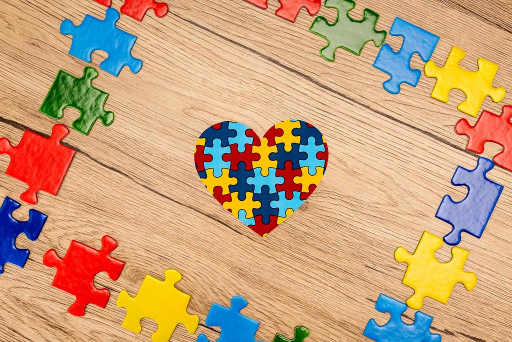 Κάτοψη του παζλ καρδιά σε ξύλινο φόντο, αυτισμός έννοια - Φωτογραφία, εικόνα