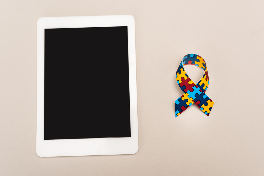 Vista superior de la cinta de conciencia y tableta digital sobre fondo blanco, concepto de autismo
 - Foto, Imagen