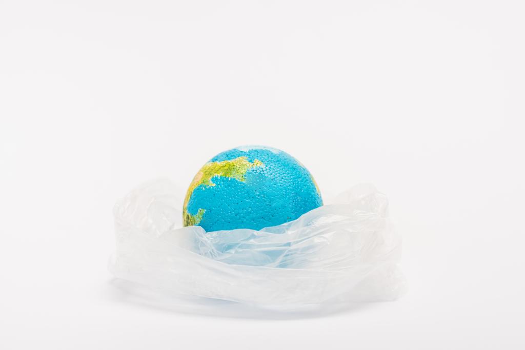 白い背景のビニール袋にグローブ、地球温暖化の概念 - 写真・画像