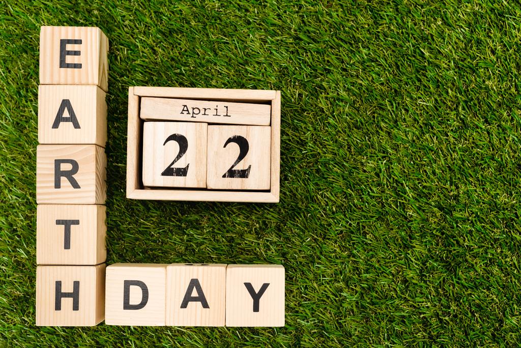 Bovenaanzicht van blokjes met aardedag en 22 april belettering op groen  - Foto, afbeelding