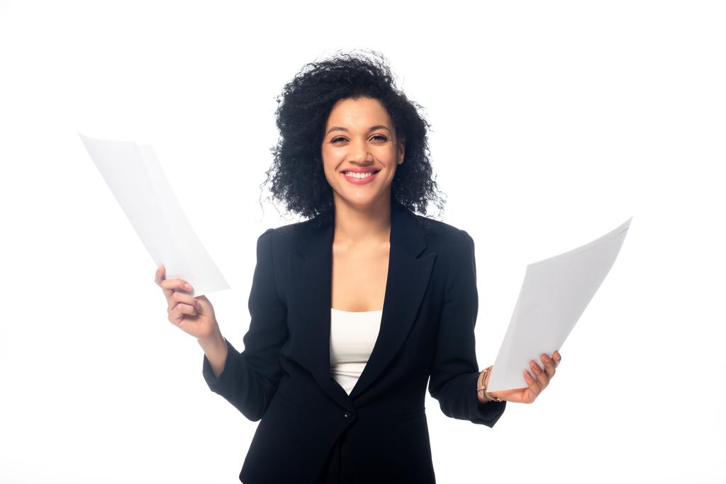 Front view of successful african american businesswoman holding papers, smiling and looking at camera isolated on white - Photo, Image