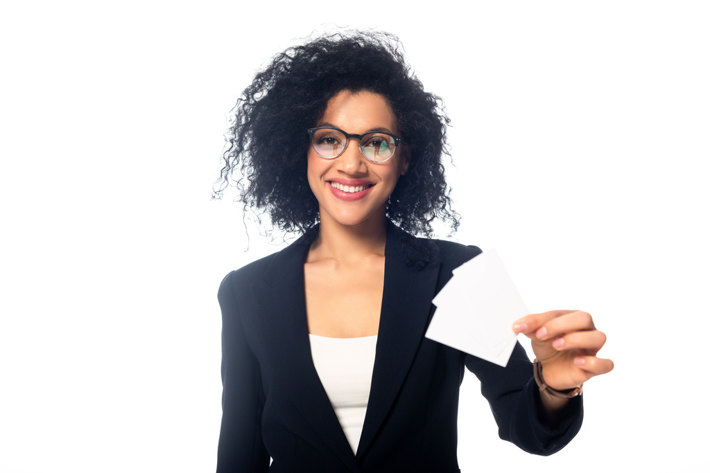 Vue de face de la femme d'affaires afro-américaine souriante et montrant des cartes de visite isolées sur blanc
 - Photo, image