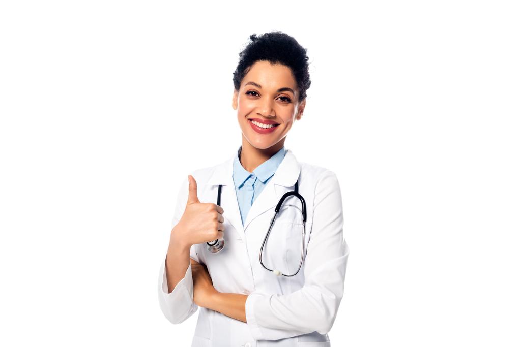 Frontansicht eines afrikanisch-amerikanischen Arztes mit Stethoskop, das wie mit erhobenem Daumen zeigt und isoliert auf weiß lächelt - Foto, Bild