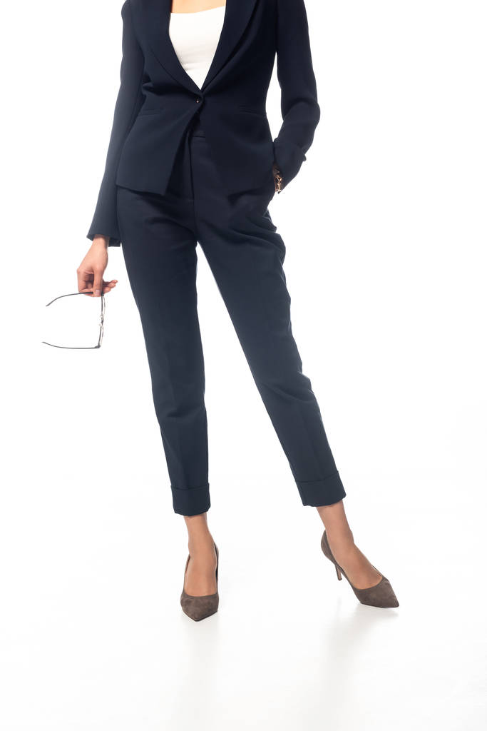 Vue recadrée d'une femme d'affaires afro-américaine avec la main dans la poche tenant des lunettes sur fond blanc
 - Photo, image