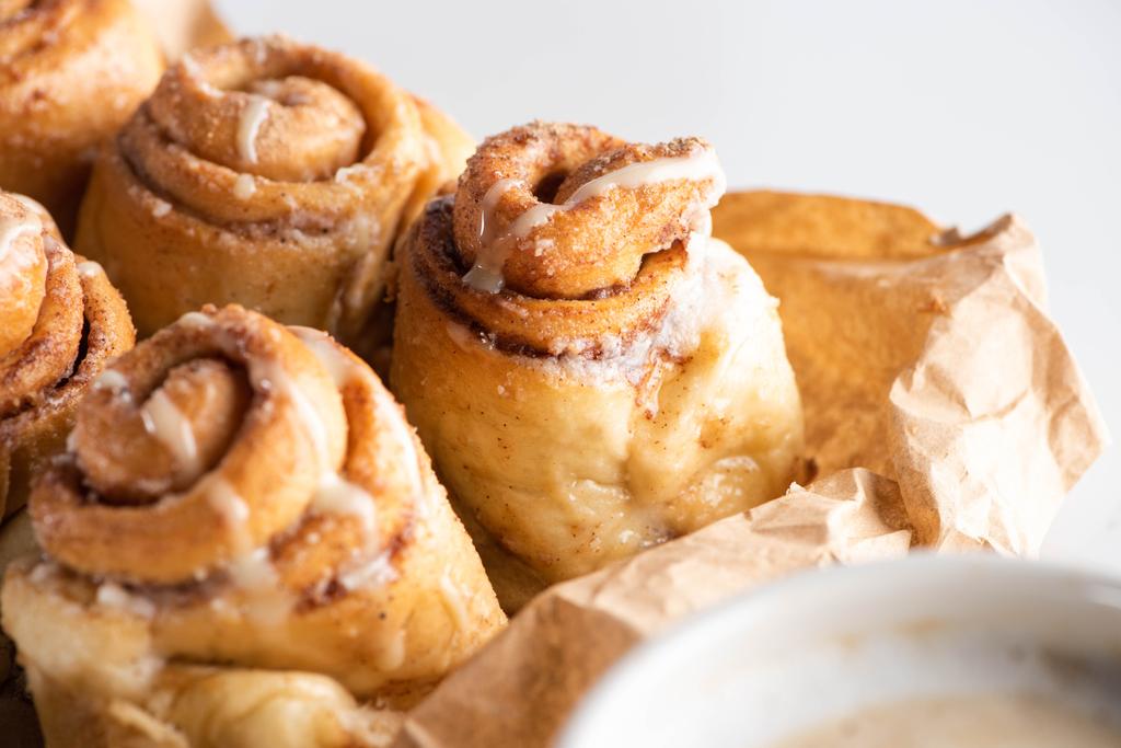 close up view of fresh delicious homemade cinnamon rolls on parchment paper - Photo, Image