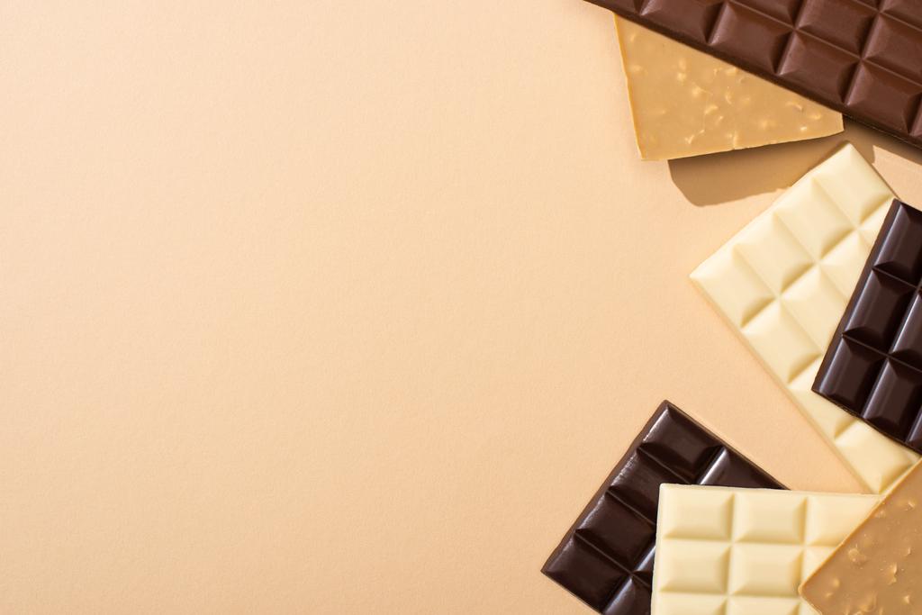 Bej üzerine izole edilmiş lezzetli çikolataların üst görüntüsü - Fotoğraf, Görsel